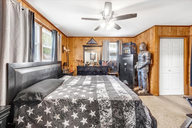 bedroom featuring crown molding, wooden walls, and wood finished floors