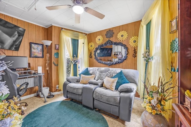 living area featuring carpet, crown molding, and a ceiling fan