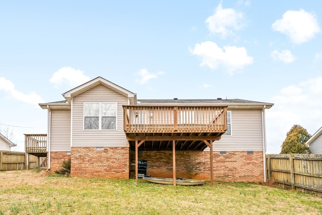 back of property featuring brick siding, a lawn, a fenced backyard, and a wooden deck