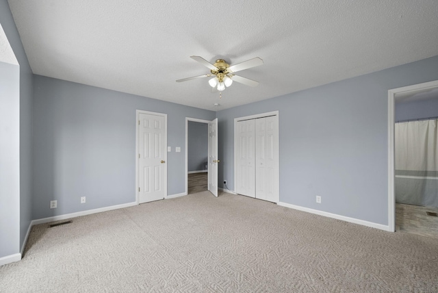 unfurnished bedroom with a ceiling fan, a textured ceiling, baseboards, and carpet flooring