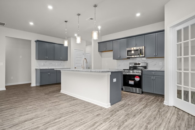 kitchen featuring stainless steel appliances, a kitchen island with sink, and gray cabinetry