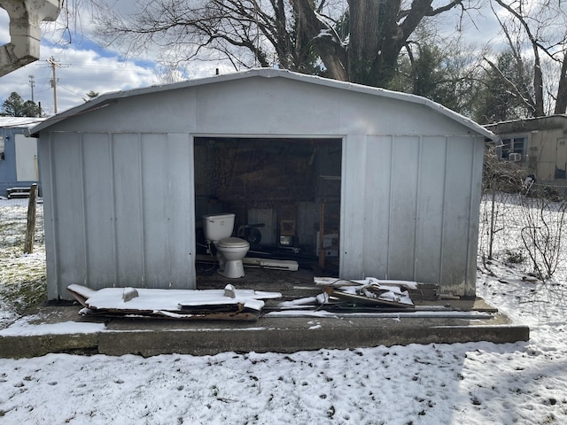 snow covered structure with an outbuilding