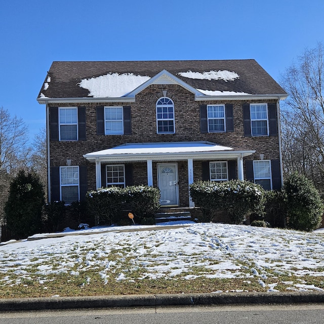 colonial home featuring brick siding