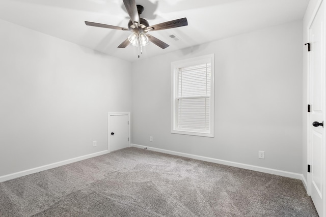 carpeted empty room featuring baseboards, visible vents, and ceiling fan