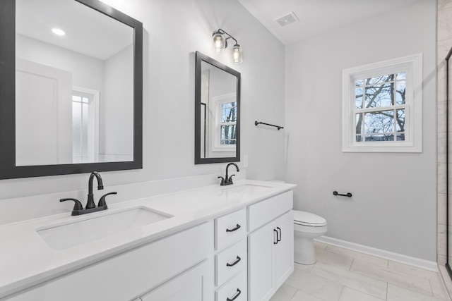 bathroom with toilet, a sink, visible vents, and baseboards