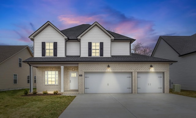 traditional-style house featuring an attached garage, brick siding, concrete driveway, roof with shingles, and a lawn