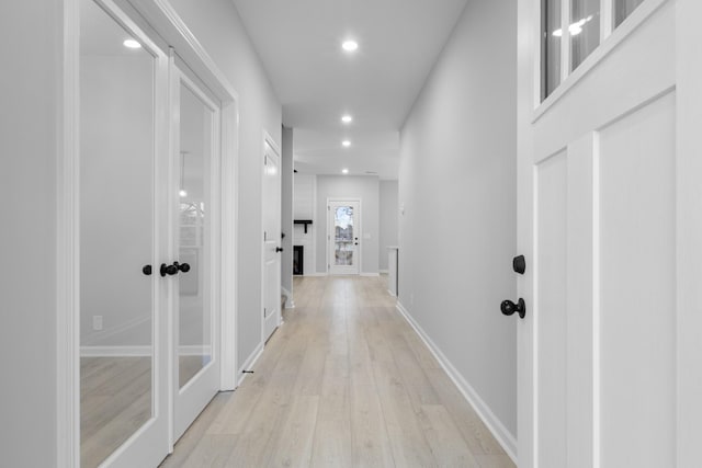 hallway featuring light wood-type flooring, baseboards, and recessed lighting