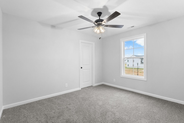 unfurnished room featuring ceiling fan, carpet floors, visible vents, and baseboards