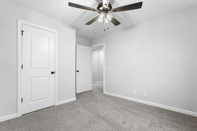 unfurnished bedroom with ceiling fan, carpet floors, and baseboards