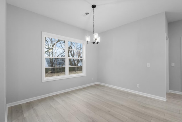 spare room with light wood-style floors, visible vents, baseboards, and a notable chandelier