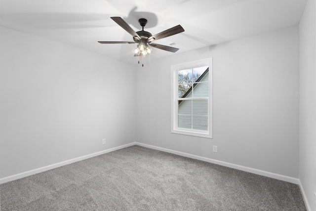 carpeted empty room featuring a ceiling fan and baseboards