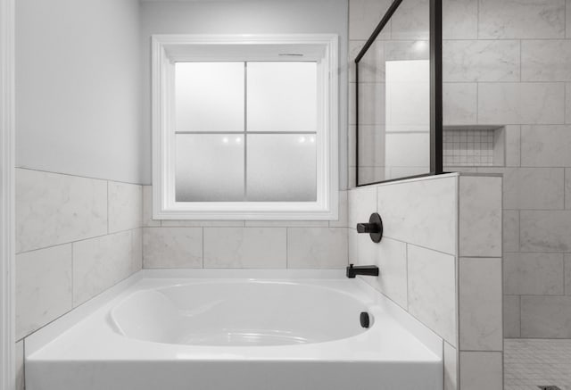 bathroom featuring a garden tub and a shower stall