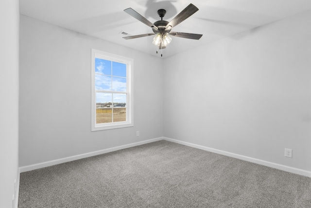 carpeted empty room featuring baseboards and a ceiling fan