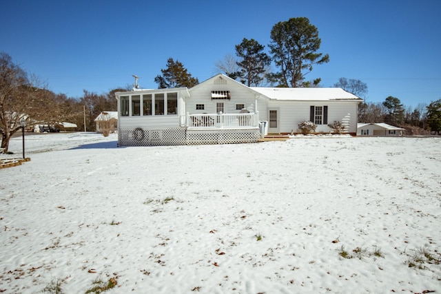 snow covered property featuring a sunroom and a wooden deck