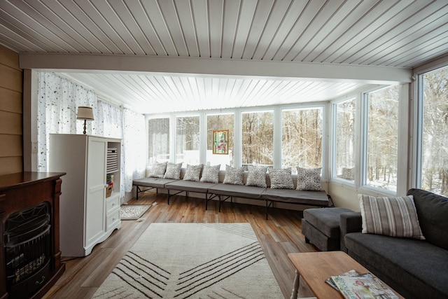 sunroom / solarium with vaulted ceiling with beams, a fireplace, and a wealth of natural light