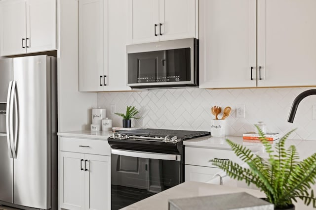 kitchen with stainless steel appliances, light countertops, and white cabinets