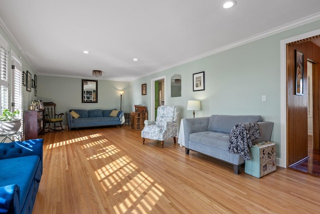 living room featuring light wood-type flooring, ornamental molding, and recessed lighting