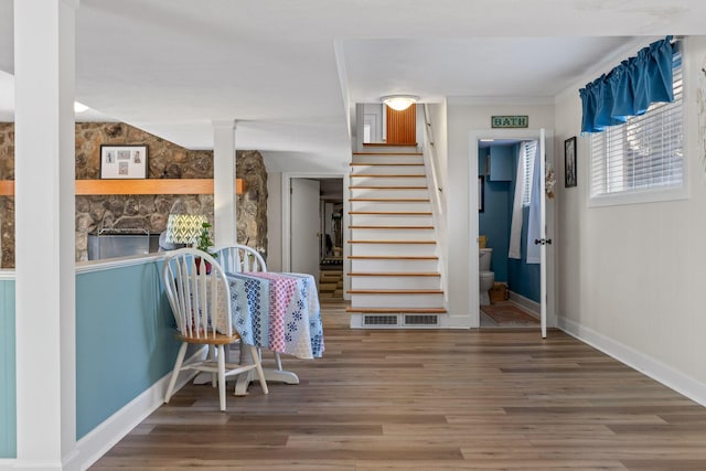 stairway with baseboards, visible vents, and wood finished floors