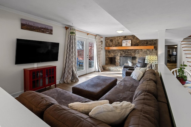 living area featuring french doors, a fireplace, wood finished floors, and baseboards