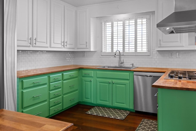 kitchen with wall chimney exhaust hood, butcher block countertops, appliances with stainless steel finishes, white cabinetry, and a sink