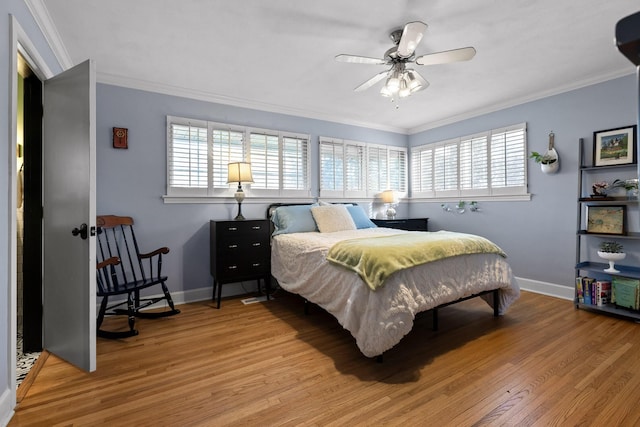 bedroom with ornamental molding, light wood-type flooring, and baseboards