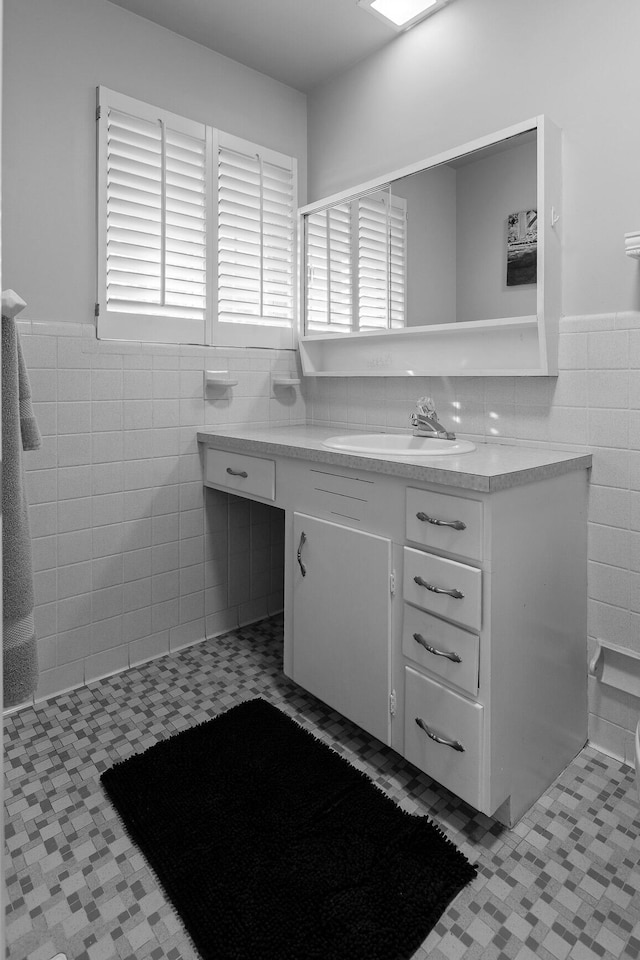 bathroom with wainscoting, tile walls, and vanity