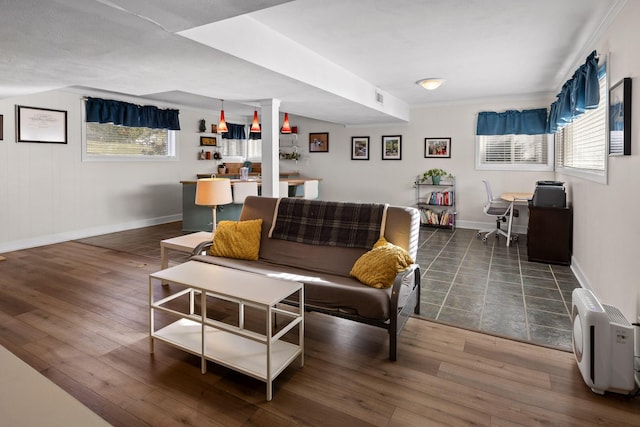 living area featuring dark wood-type flooring, a wealth of natural light, visible vents, and baseboards