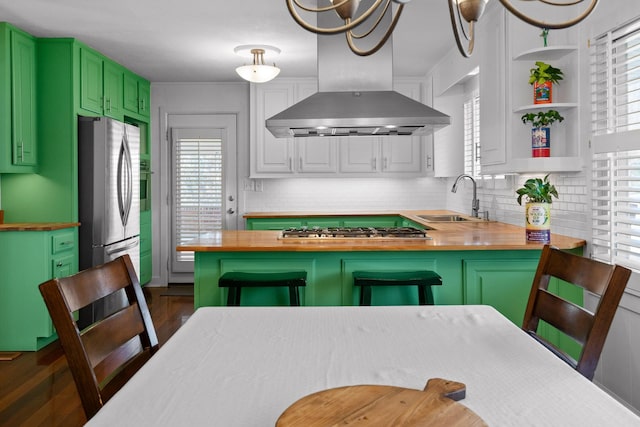 kitchen with butcher block counters, range hood, open shelves, and a sink