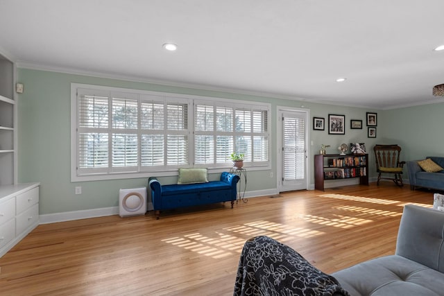 living room with ornamental molding, light wood-type flooring, and baseboards