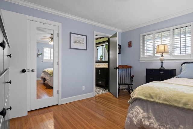 bedroom featuring ornamental molding, baseboards, and wood finished floors