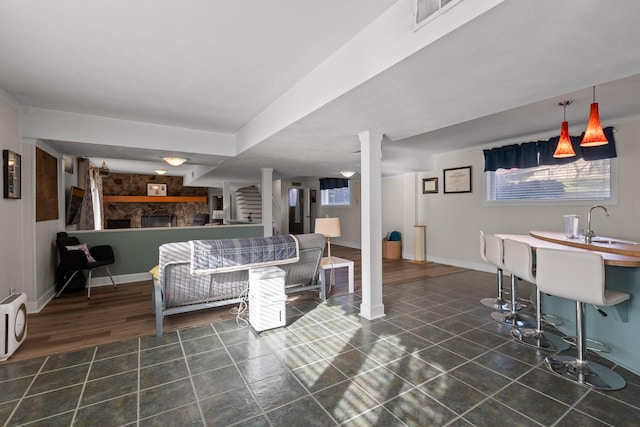 living room featuring visible vents, a fireplace, dark tile patterned floors, and baseboards