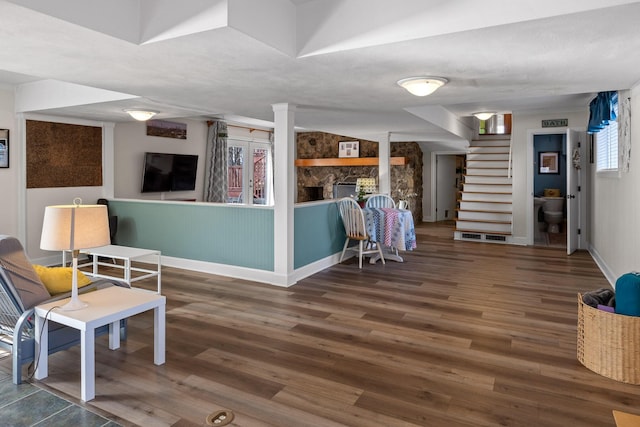 interior space with a fireplace, dark wood finished floors, stairway, and baseboards