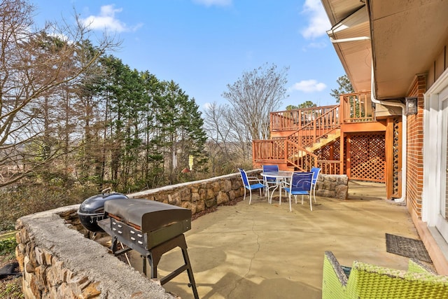 view of patio / terrace with a deck, outdoor dining area, stairway, and area for grilling