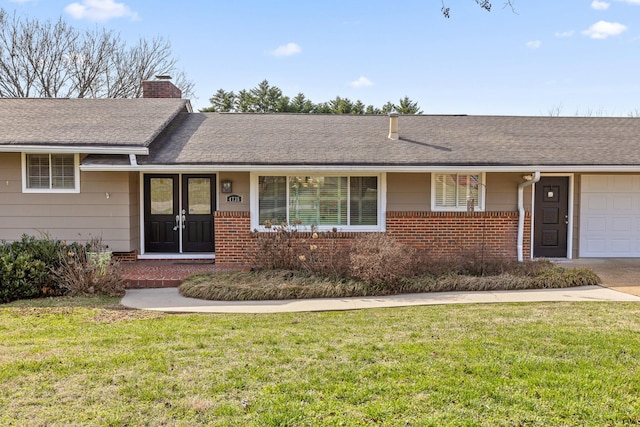 single story home featuring a garage, brick siding, a chimney, and a front lawn