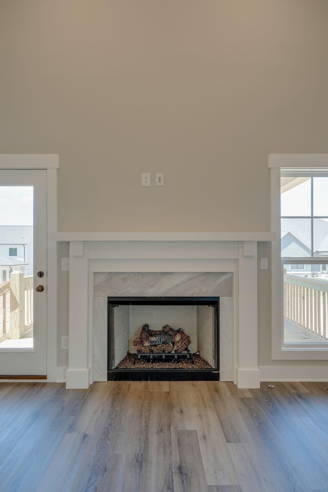 room details with a high end fireplace, baseboards, and wood finished floors