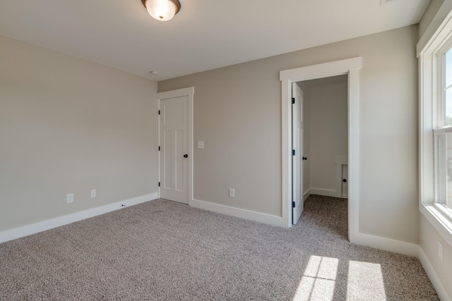 unfurnished bedroom featuring light carpet and baseboards