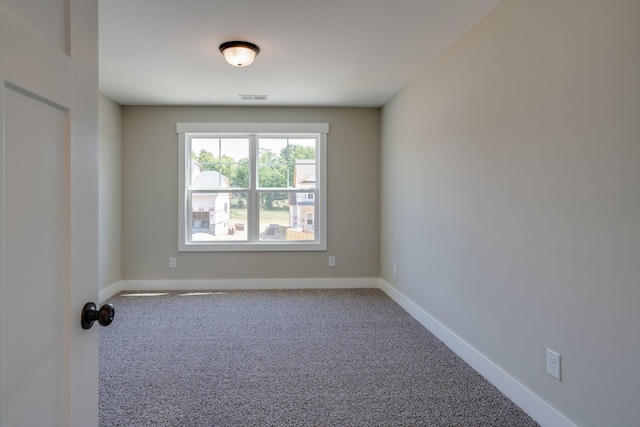 carpeted empty room featuring visible vents and baseboards