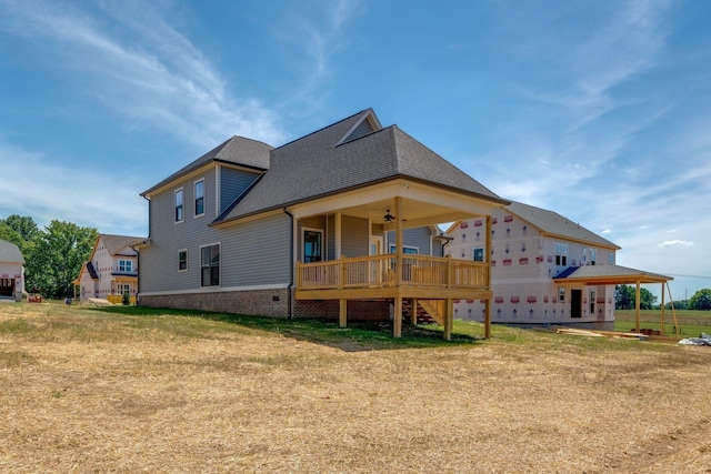 back of house featuring stairs, a shingled roof, a lawn, and a ceiling fan