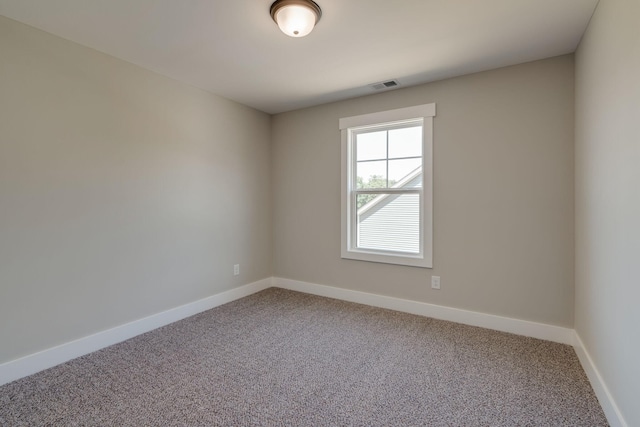 carpeted empty room with visible vents and baseboards