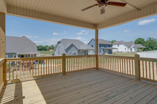 wooden deck with ceiling fan, fence, and a residential view