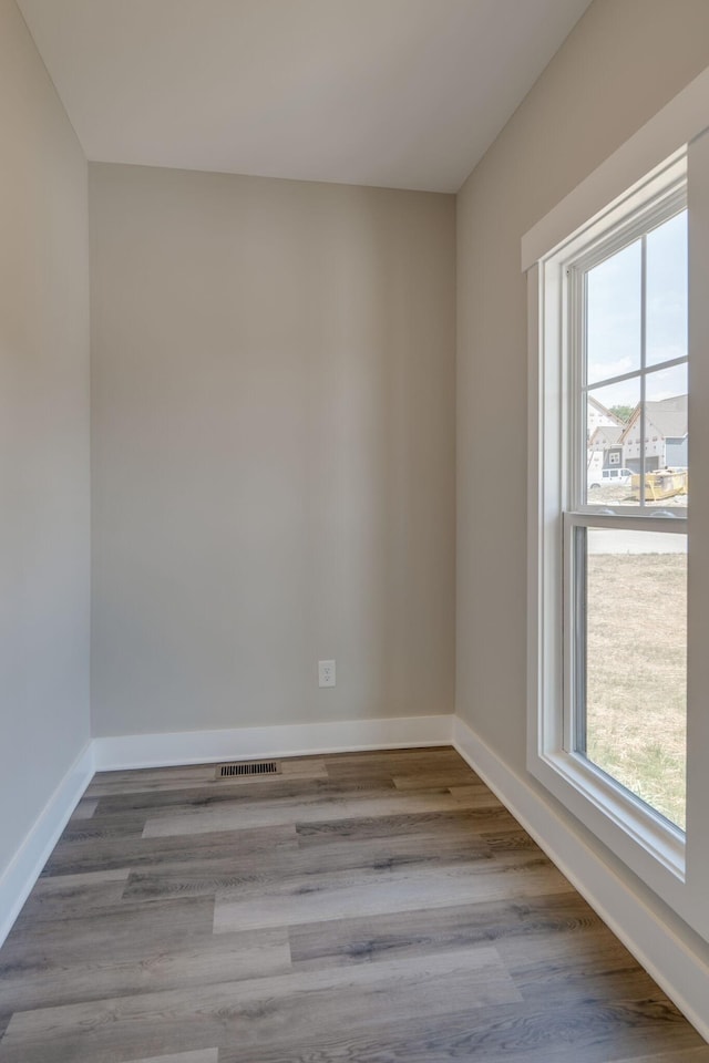 unfurnished room with visible vents, light wood-style flooring, and baseboards