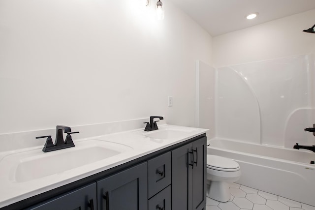 bathroom featuring tile patterned flooring, a sink, toilet, and double vanity