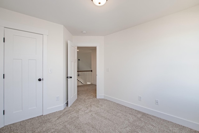 unfurnished bedroom featuring light colored carpet and baseboards