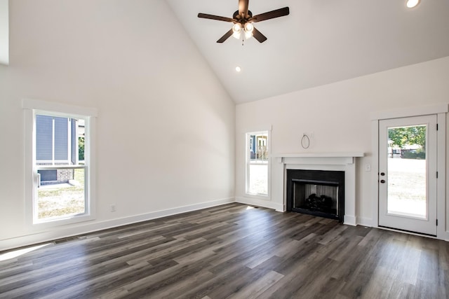 unfurnished living room with a fireplace, dark wood finished floors, ceiling fan, high vaulted ceiling, and baseboards