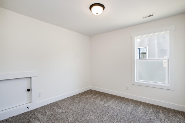 spare room with visible vents, baseboards, and carpet flooring