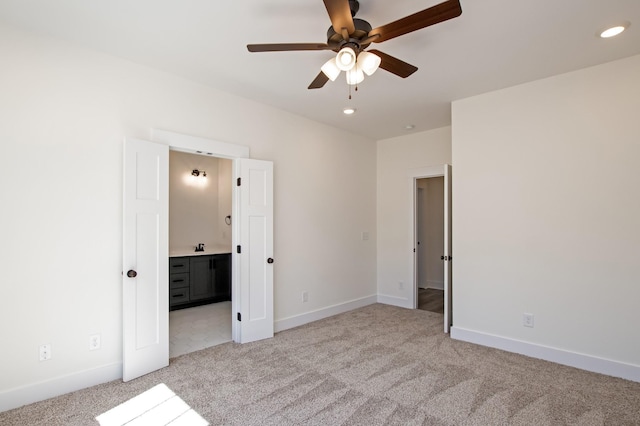 unfurnished bedroom featuring recessed lighting, light colored carpet, baseboards, and ensuite bathroom