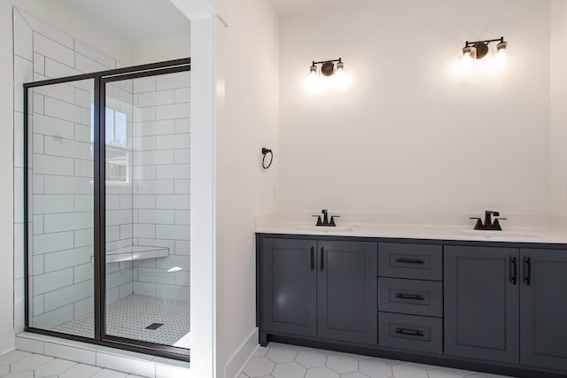 bathroom with a sink, a shower stall, and double vanity