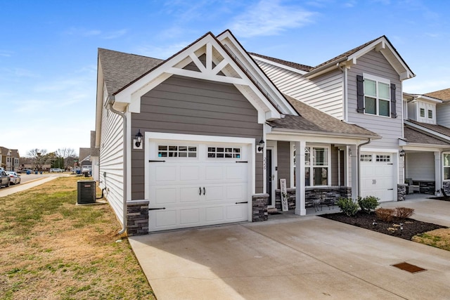 view of front of property featuring roof with shingles, driveway, an attached garage, and central AC unit