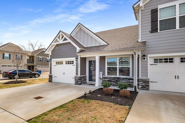 view of front of property with an attached garage, stone siding, board and batten siding, and concrete driveway