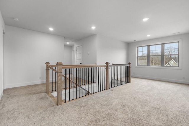 spare room featuring recessed lighting, baseboards, and light colored carpet